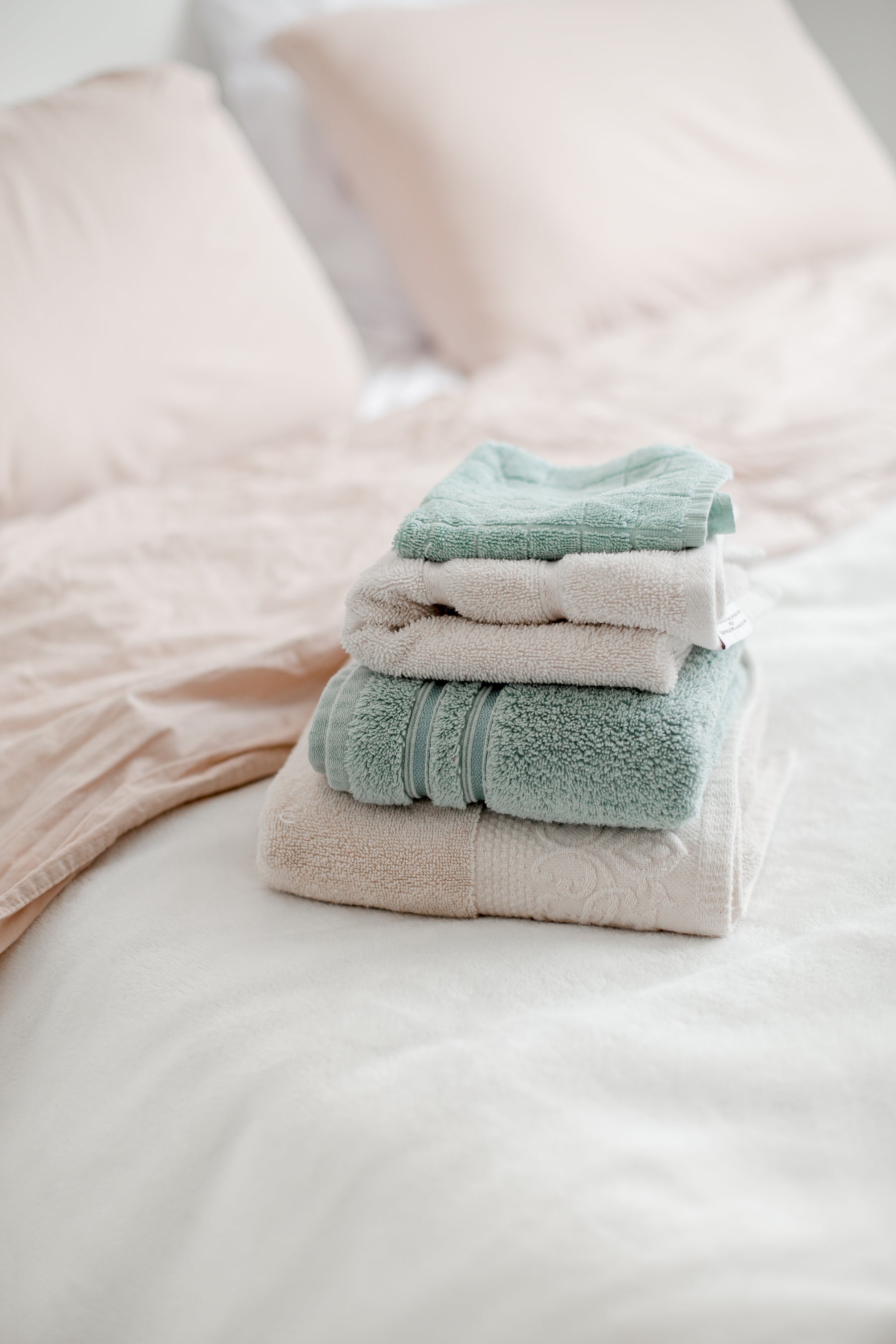Neatly folded towels placed on a bed